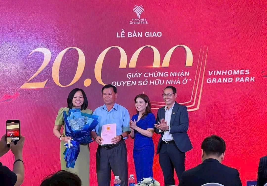 Lễ bàn giao 20.000 giấy chứng nhận quyền sở hữu nhà ở tại Vinhomes Grand Park, đại diện chủ đầu tư trao sổ cho cư dân trên sân khấu nền đỏ